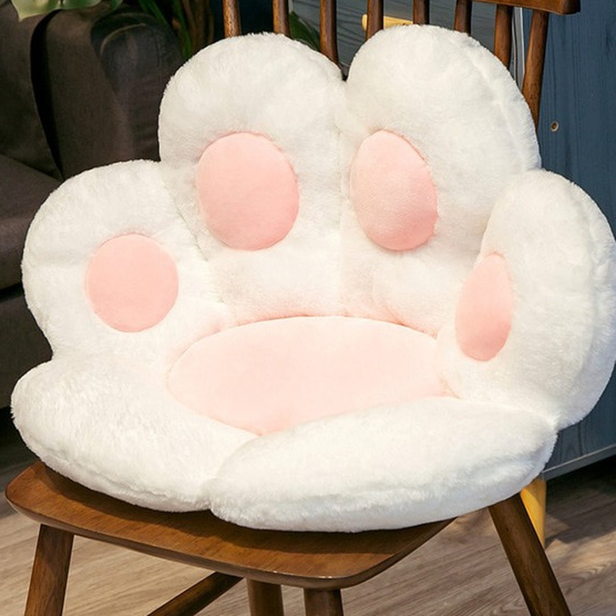 Coussin de sol patte de chat blanc de 45 cm posé sur une chaise en bois
