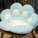 Coussin de sol patte de chat bleu de 45 cm posé sur une chaise en bois