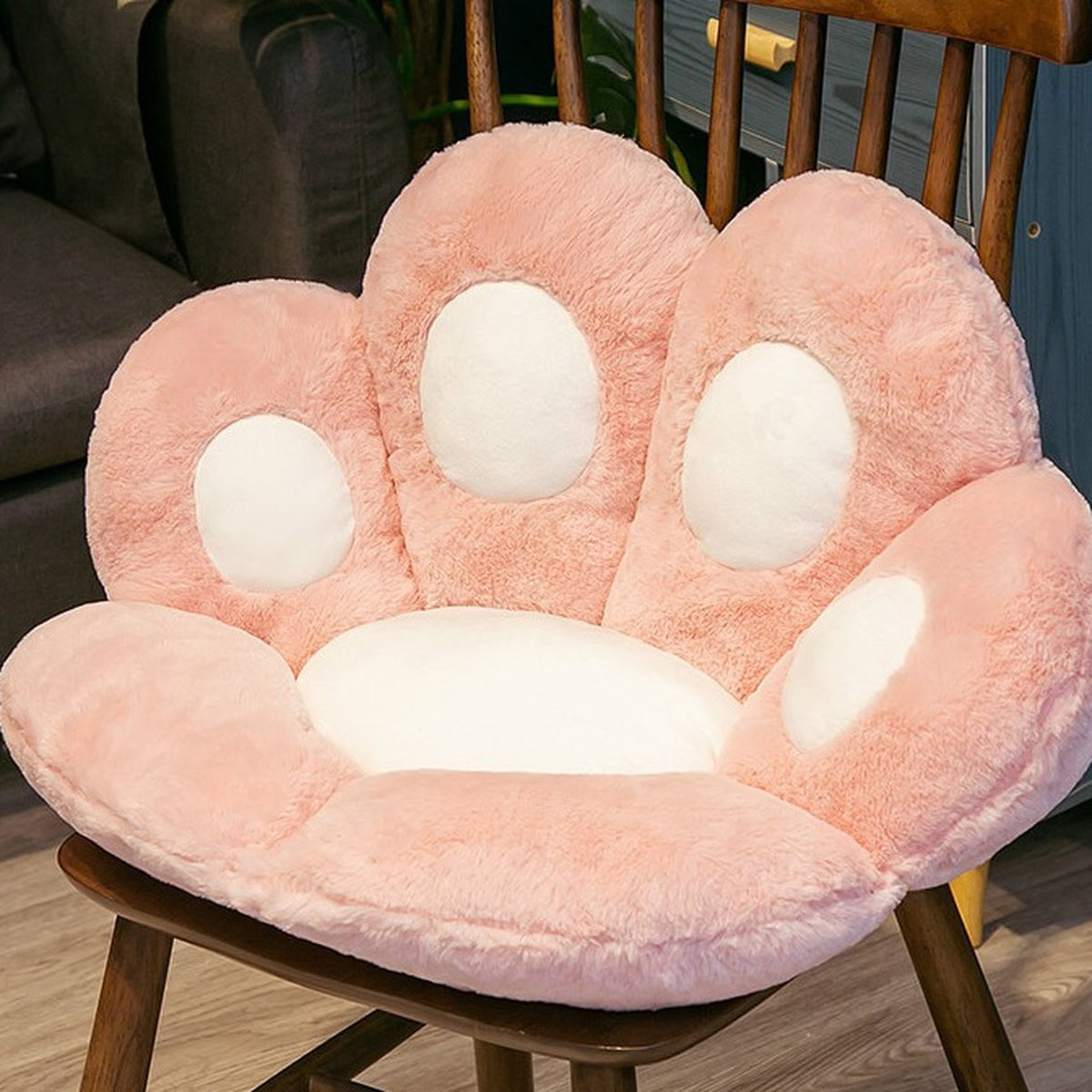 Coussin de sol patte de chat rose de 45 cm posé sur une chaise en bois