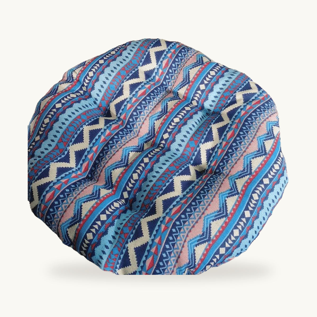 Coussin de sol rond capitonné à motif géométrique bleu et rose sur fond clair