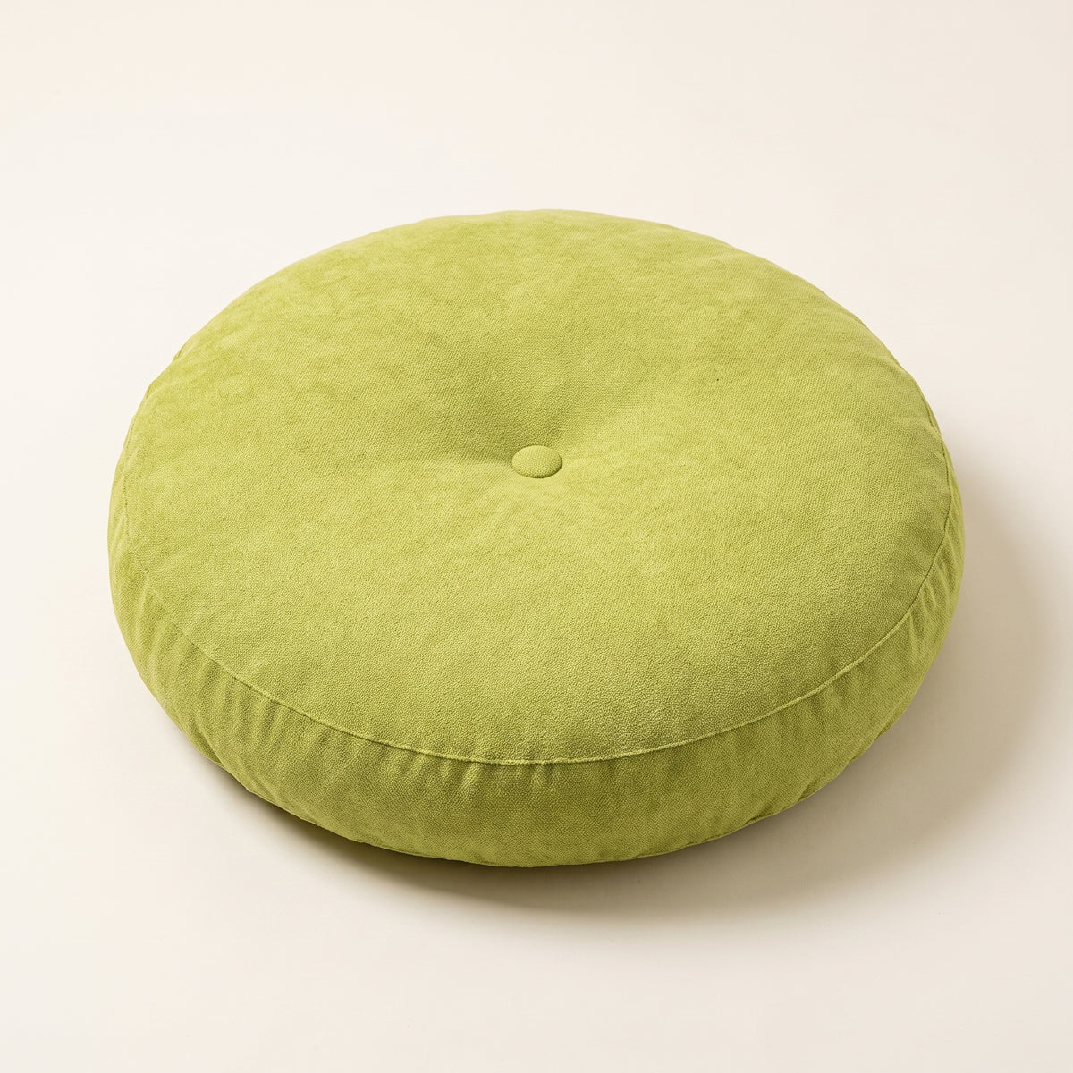 Coussin de sol rond vert avec bouton central et couture latérale