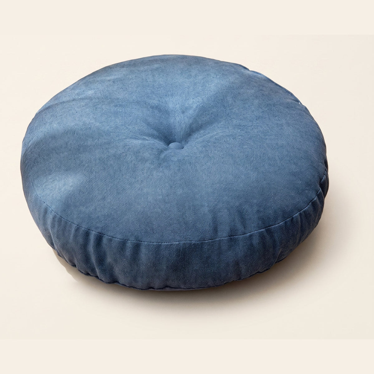 Coussin de sol rond bleu avec bouton central et couture latérale