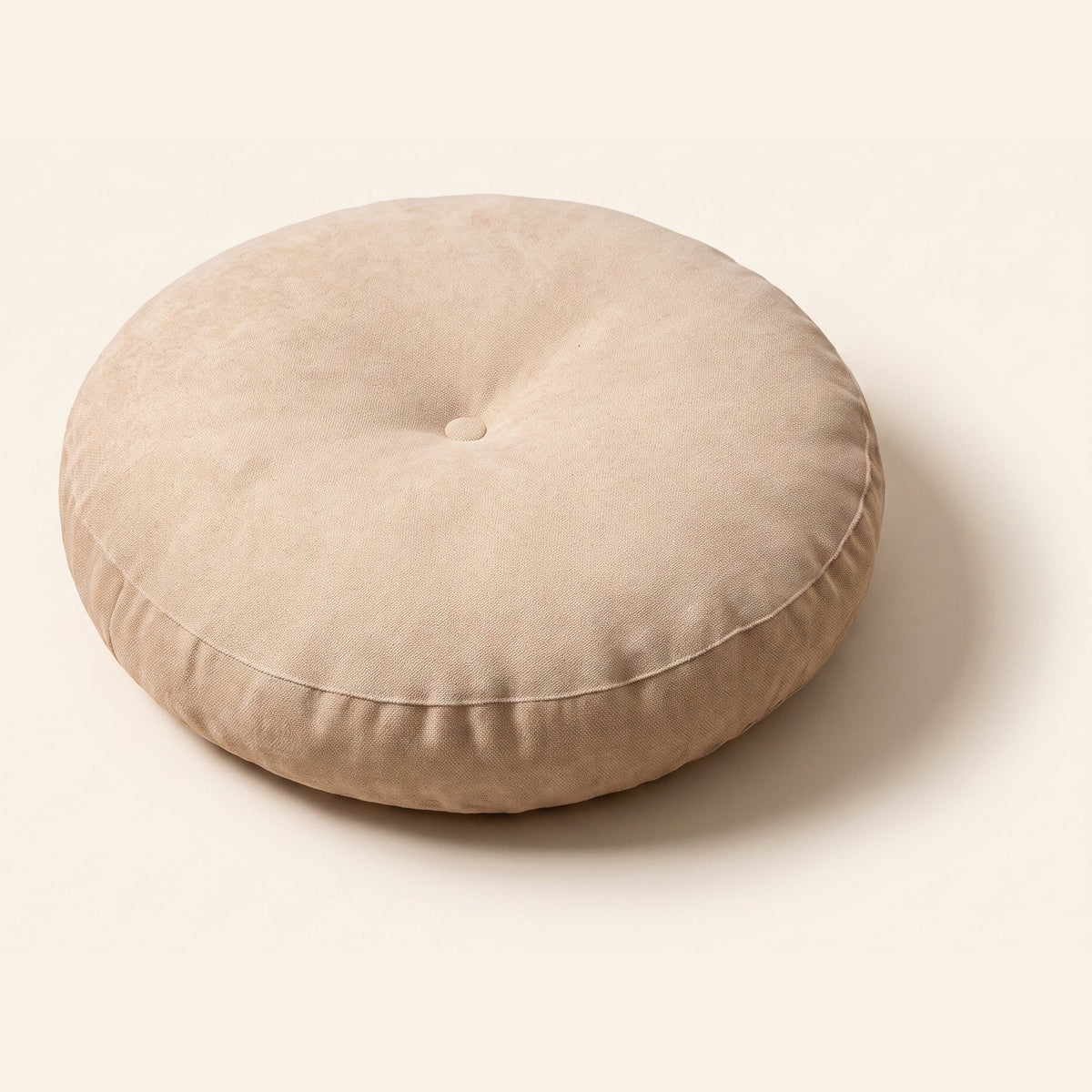 Coussin de sol rond beige avec bouton central et couture latérale