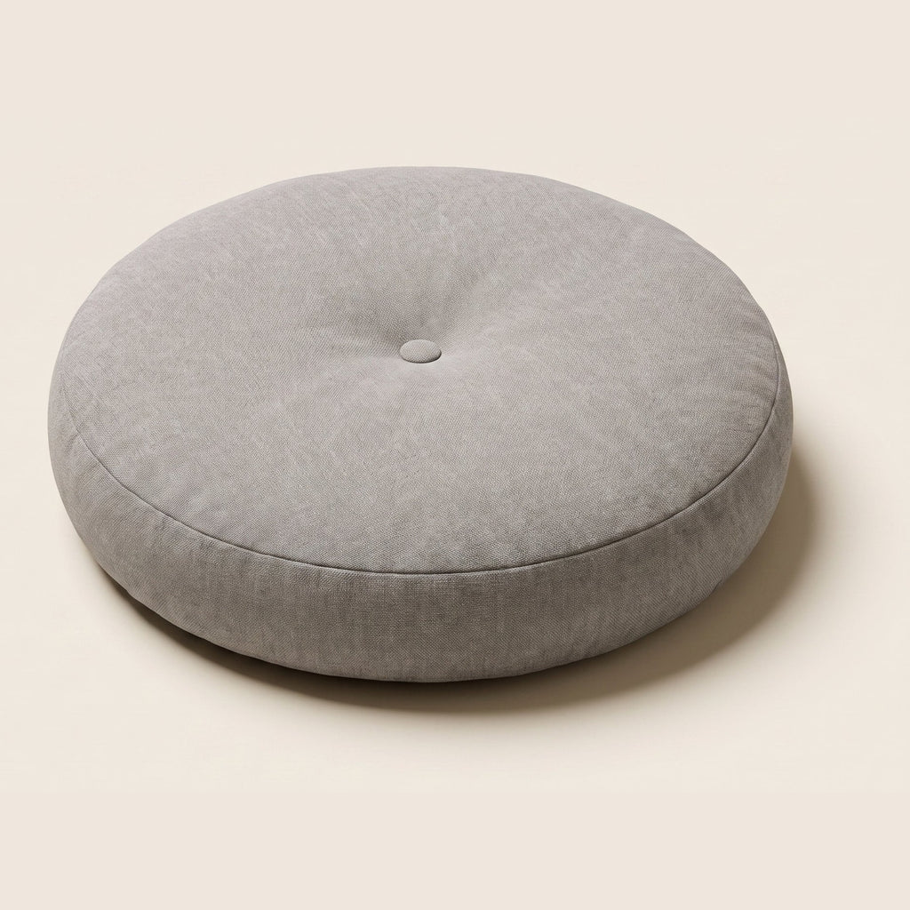 Coussin de sol rond gris avec bouton central et couture latérale