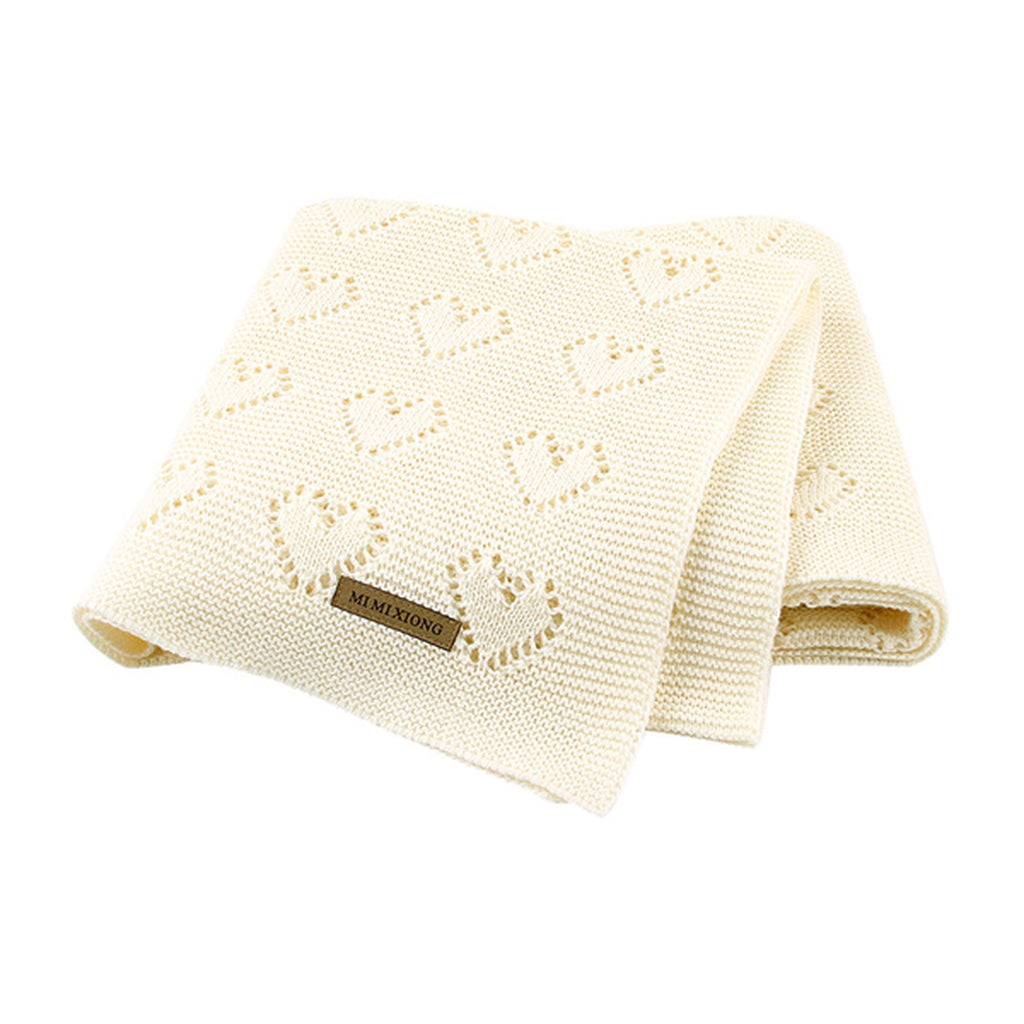 Couverture bébé beige à cœurs sur fond blanc