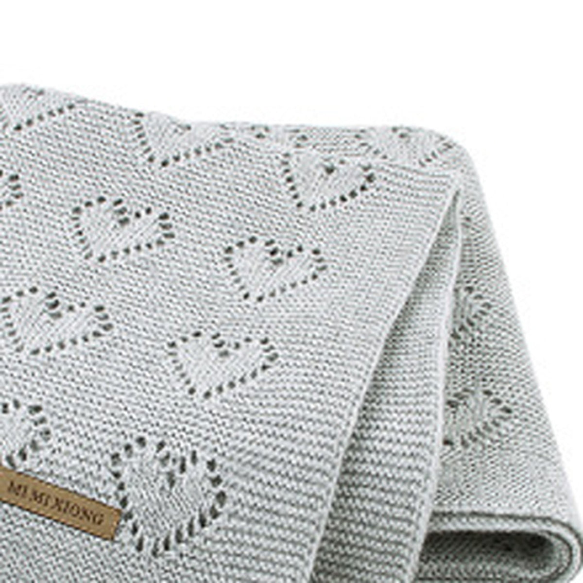 Gros plan sur la maille ajourée à cœurs de la couverture bébé gris clair Image