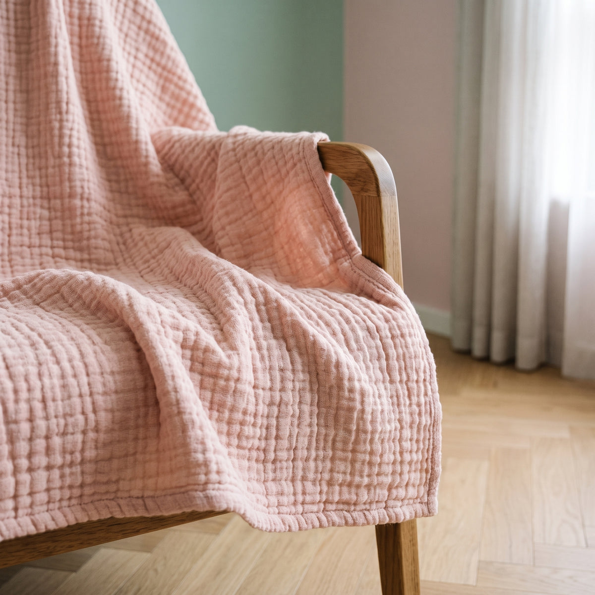 Couverture bébé rose drapée sur un fauteuil dans une chambre d’enfant lumineuse