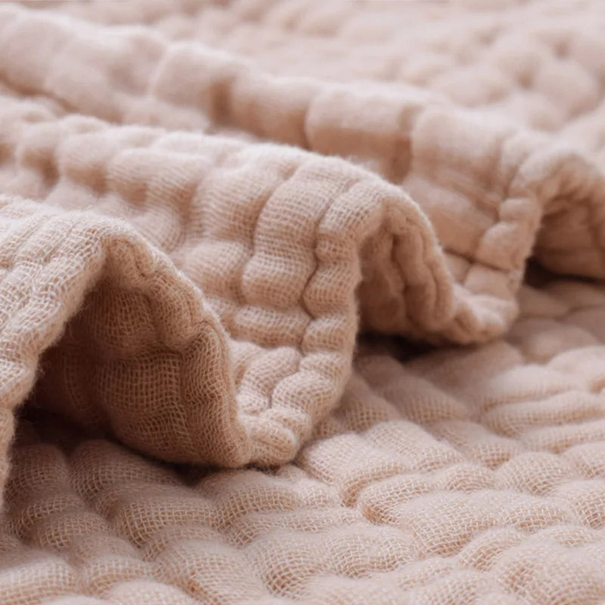 Gros plan sur le relief gaufré et les plis de la couverture bébé marron