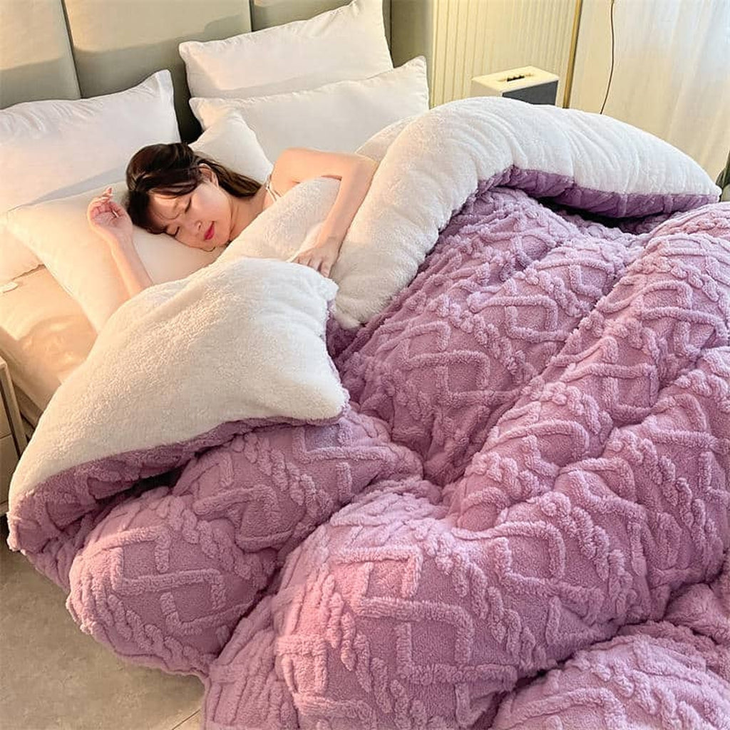 Couverture épaisse rose déployée sur un lit double, face claire rabattue