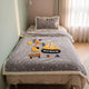 Couverture bébé grise à motif chantier posée sur un lit d’enfant