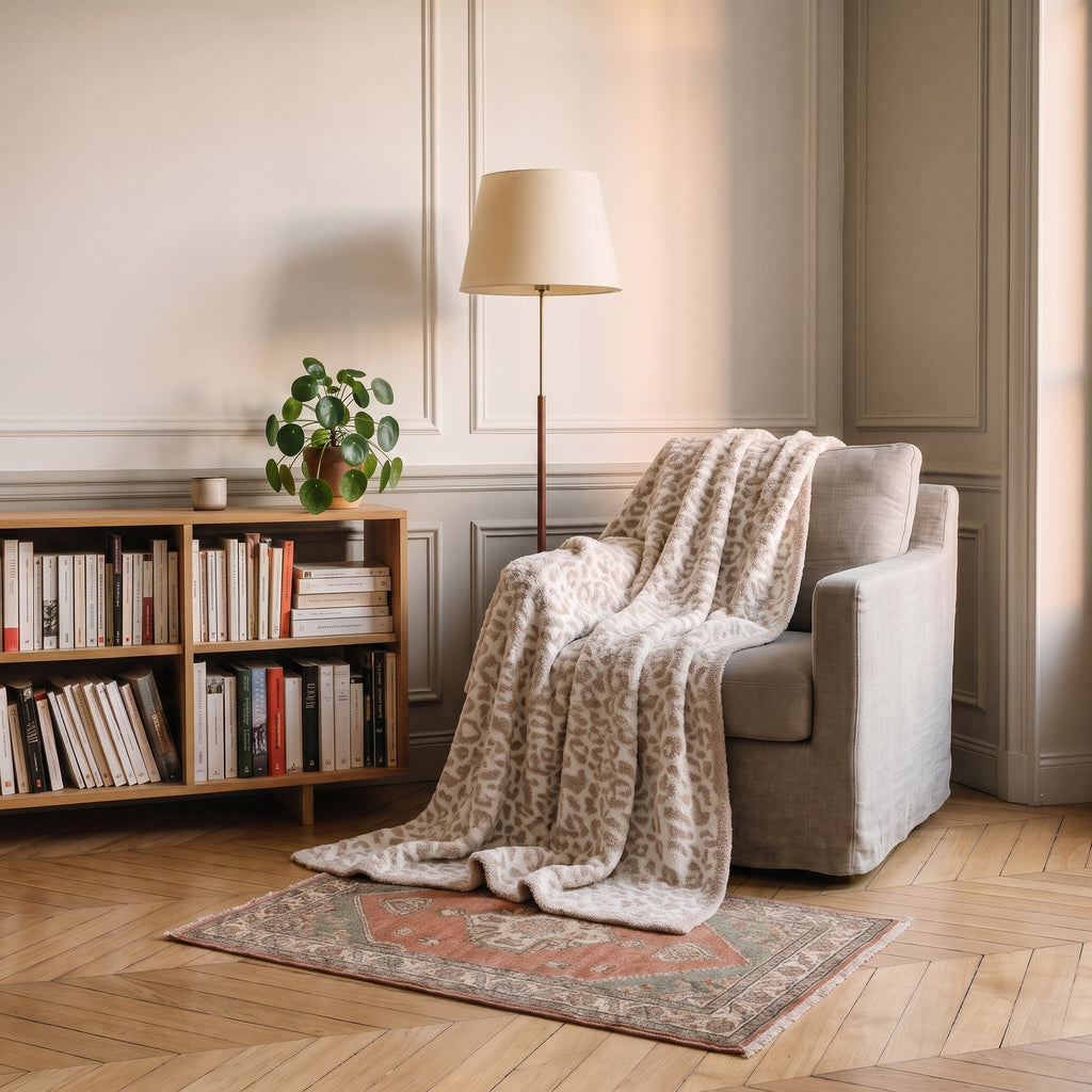 Plaid léopard crème posé sur un fauteuil de lecture
