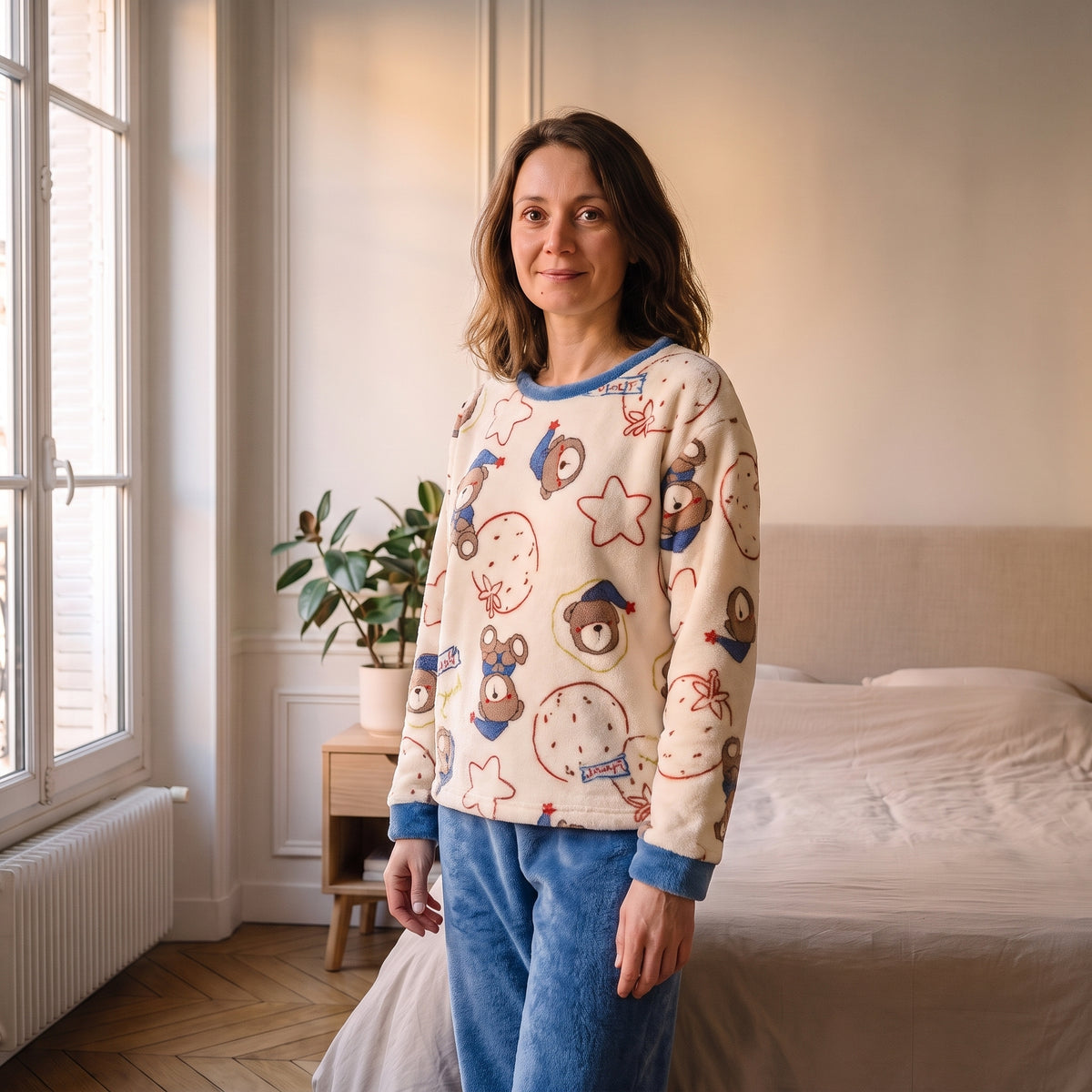 Femme portant le pyjama d'hiver crème imprimé pantalon bleu dans une chambre lumineuse