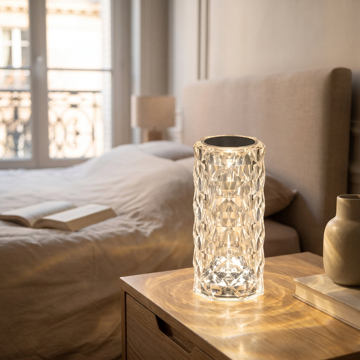 Détail du relief facetté et du sommet de la lampe LED crystal touch sur une table de chevet