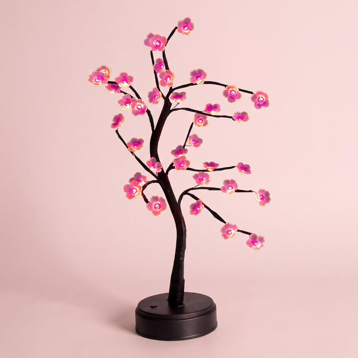 Détail des fleurs roses lumineuses et des branches de la lampe bonsaï LED