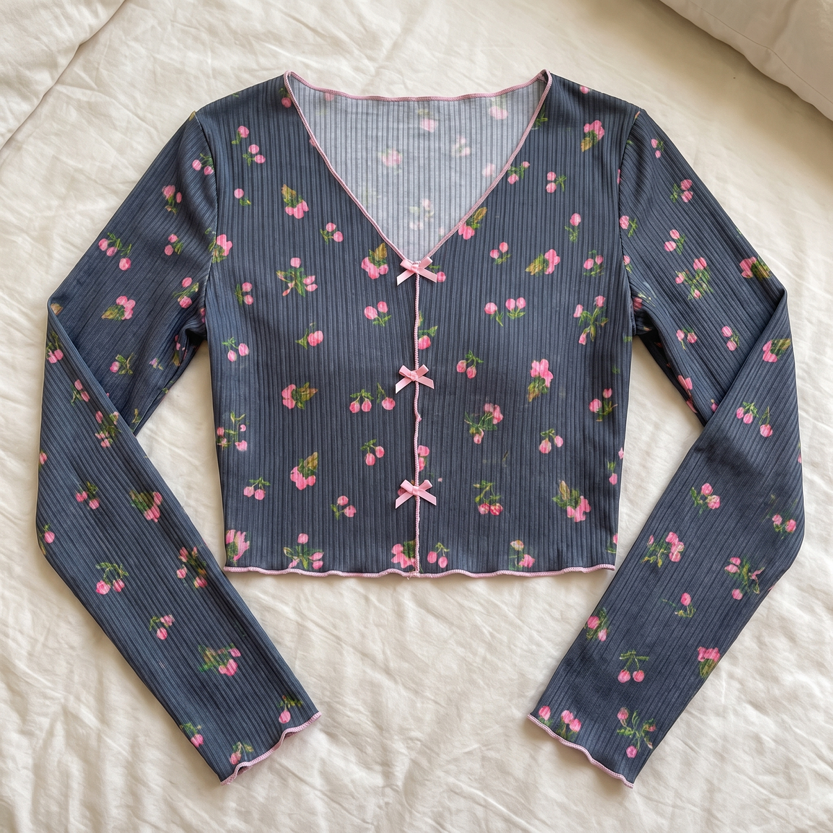 Vue rapprochée des trois liens noués du haut du pyjama floral gris.