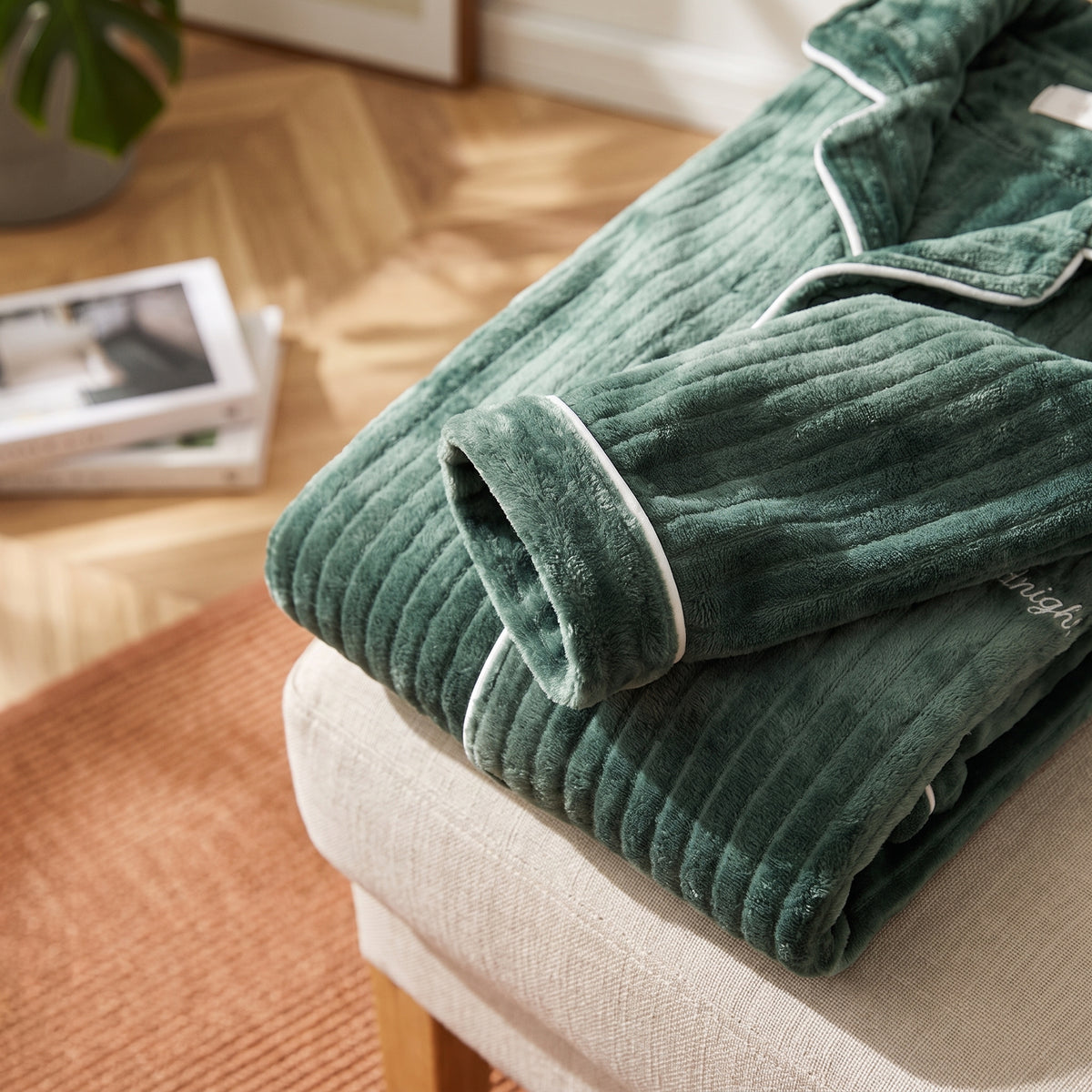 Détail des côtes de la maille peluche et du passepoil clair au poignet du pyjama vert sapin Image