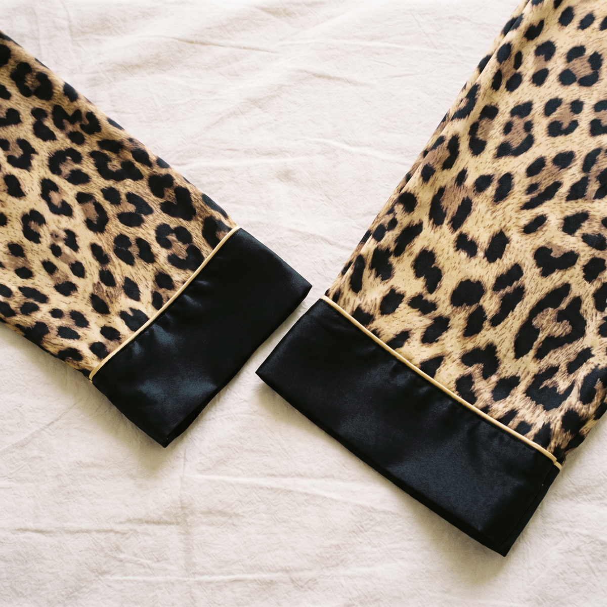 Vue rapprochée du revers de manche noir et du bas de jambe du pantalon.