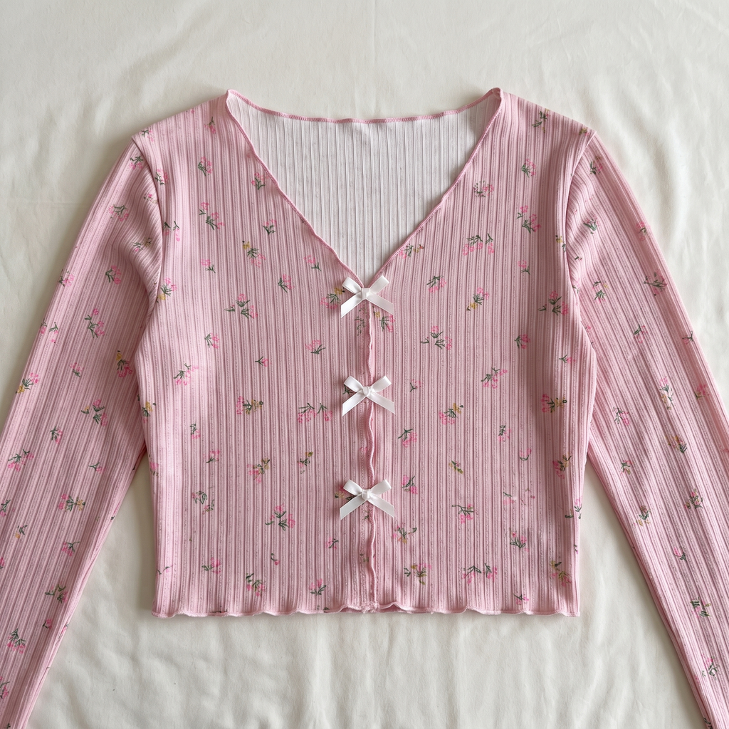 Vue rapprochée des trois liens noués du haut du pyjama floral rose.