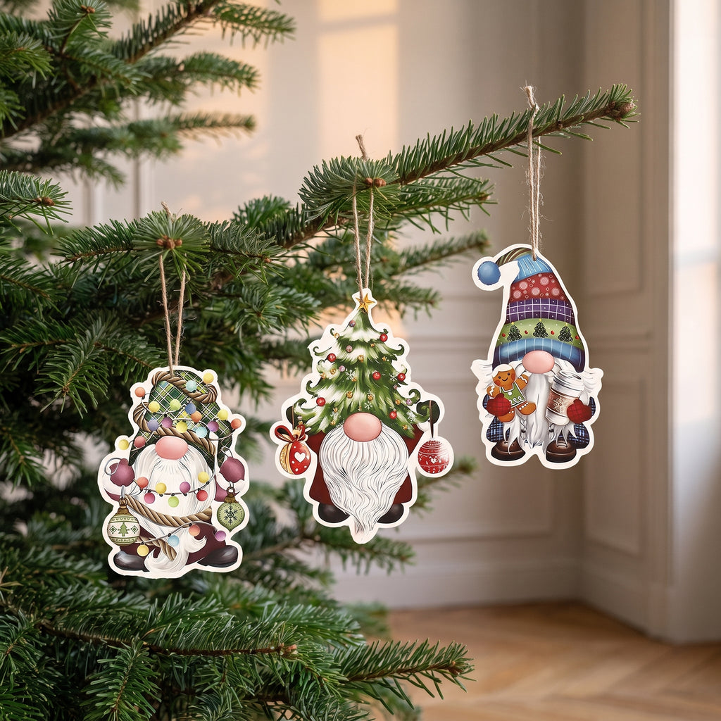 Détail de trois suspensions de Noël gnomes en papier, de la taille d’une boule de Noël, sur les branches