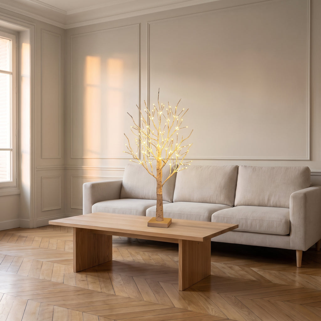 Lampe LED en forme d'arbre posée sur une table basse du salon