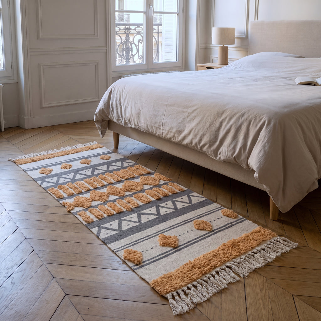 Tapis d'inspiration orientale au pied du lit, vue au ras du parquet