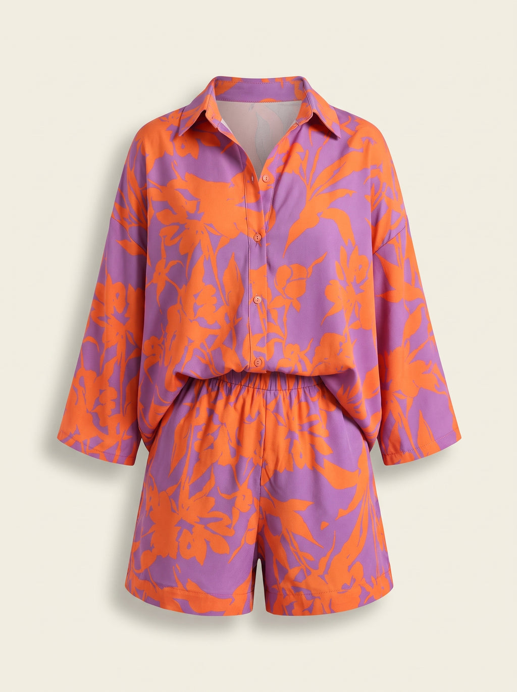 Ensemble chemise et short orange et lilas présenté sur mannequin invisible.