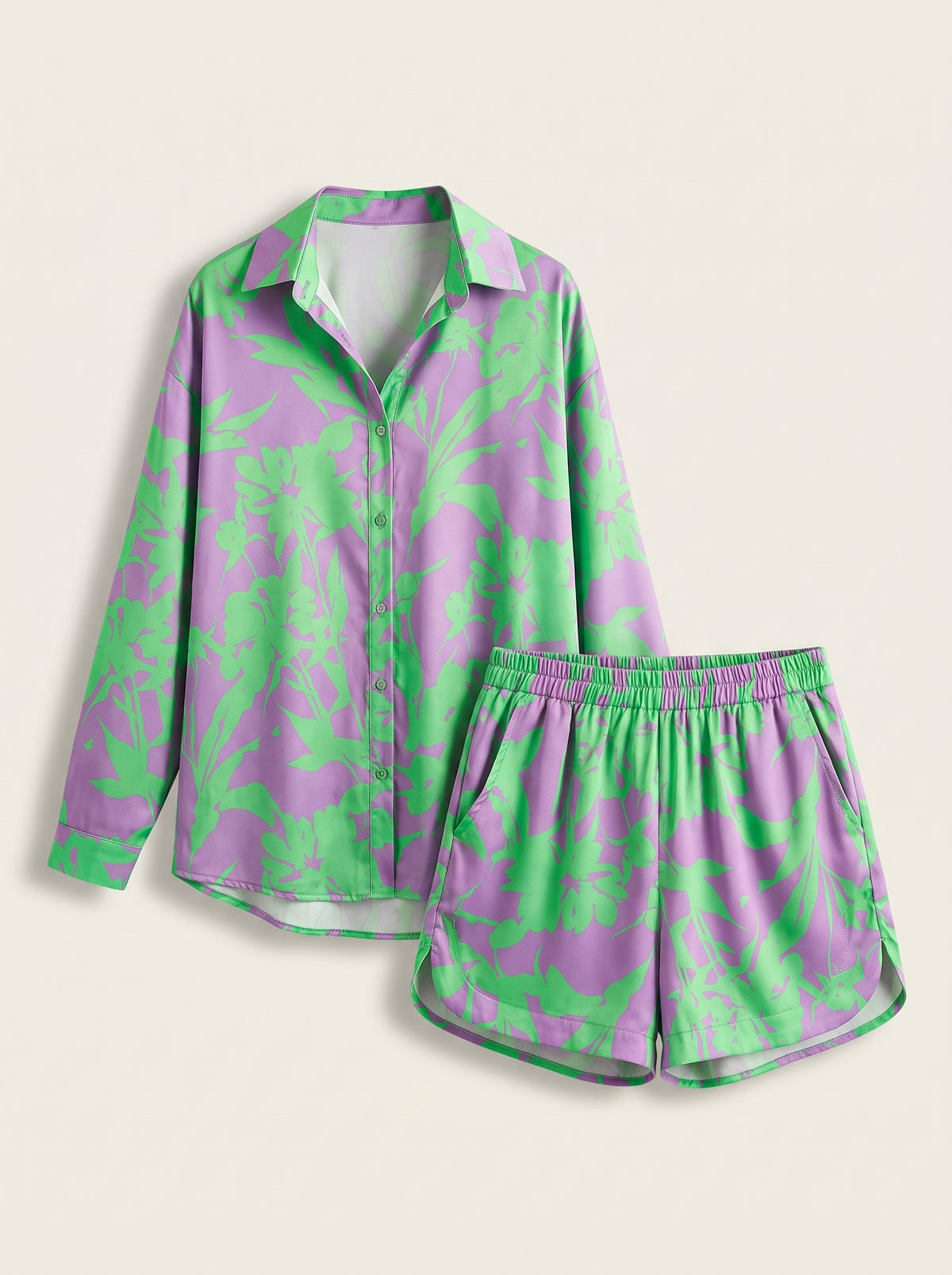 Ensemble chemise et short vert et lilas présenté à plat sur fond blanc cassé.