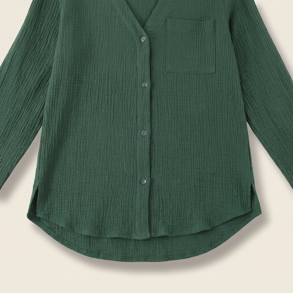 Chemise verte présentée à plat, poche poitrine, boutonnage et ourlet arrondi