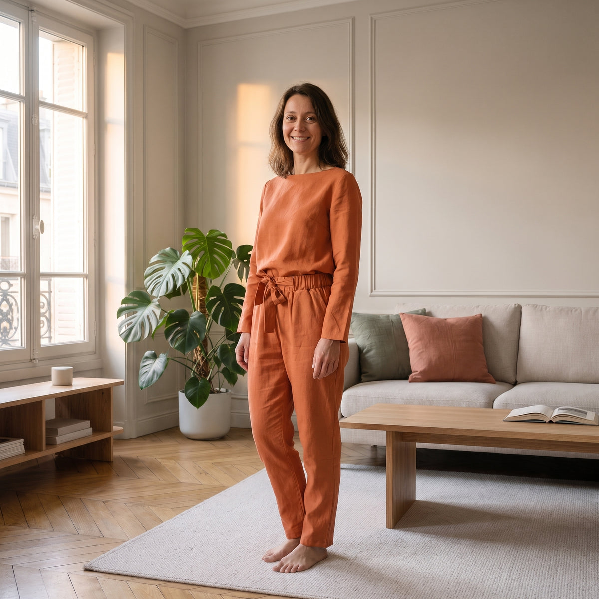 Ensemble en coton et lin orange terracotta porté, col bateau et pantalon à taille nouée, dans un salon clair