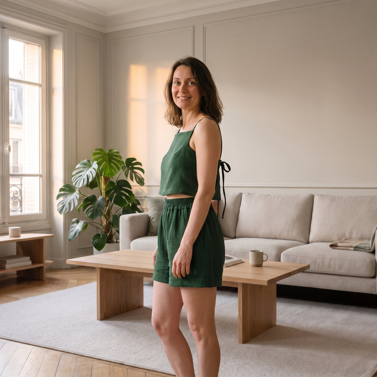 Femme portant l'ensemble d'été vert dans un salon lumineux Image