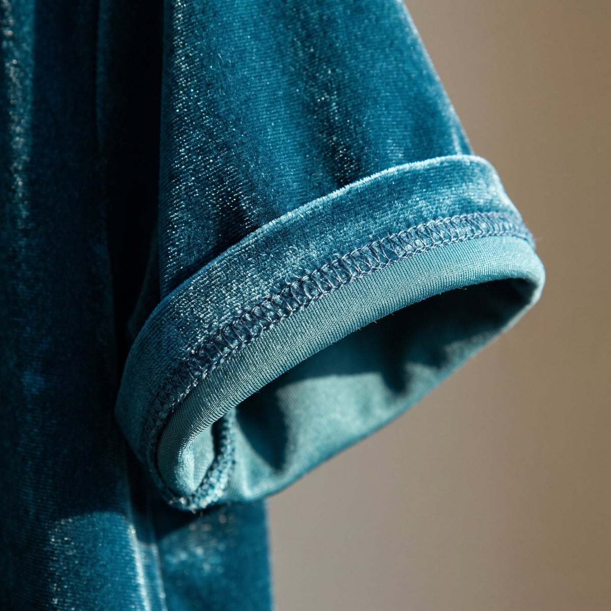 Détail du revers de manche replié de l'ensemble en velours bleu canard, poil ras sur l'endroit et tricot fin sur l'envers. Image