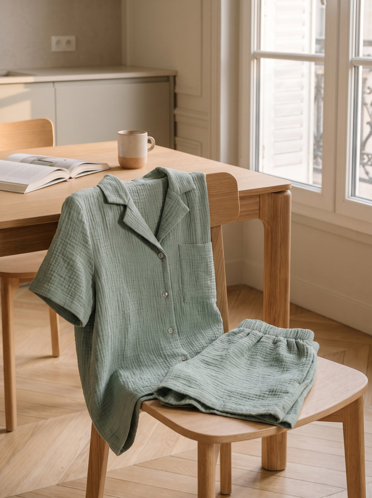Ensemble en gaze de coton posé sur le dossier d'une chaise dans un coin repas le matin