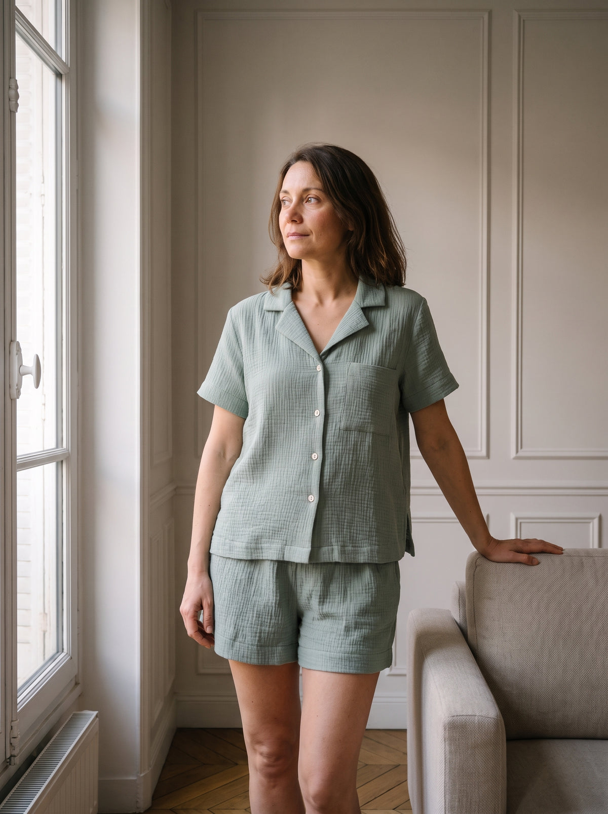 Ensemble chemise et short en gaze de coton vert sauge porté dans un salon clair