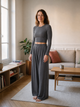 Femme portant l'ensemble gris foncé à pantalon large dans le salon