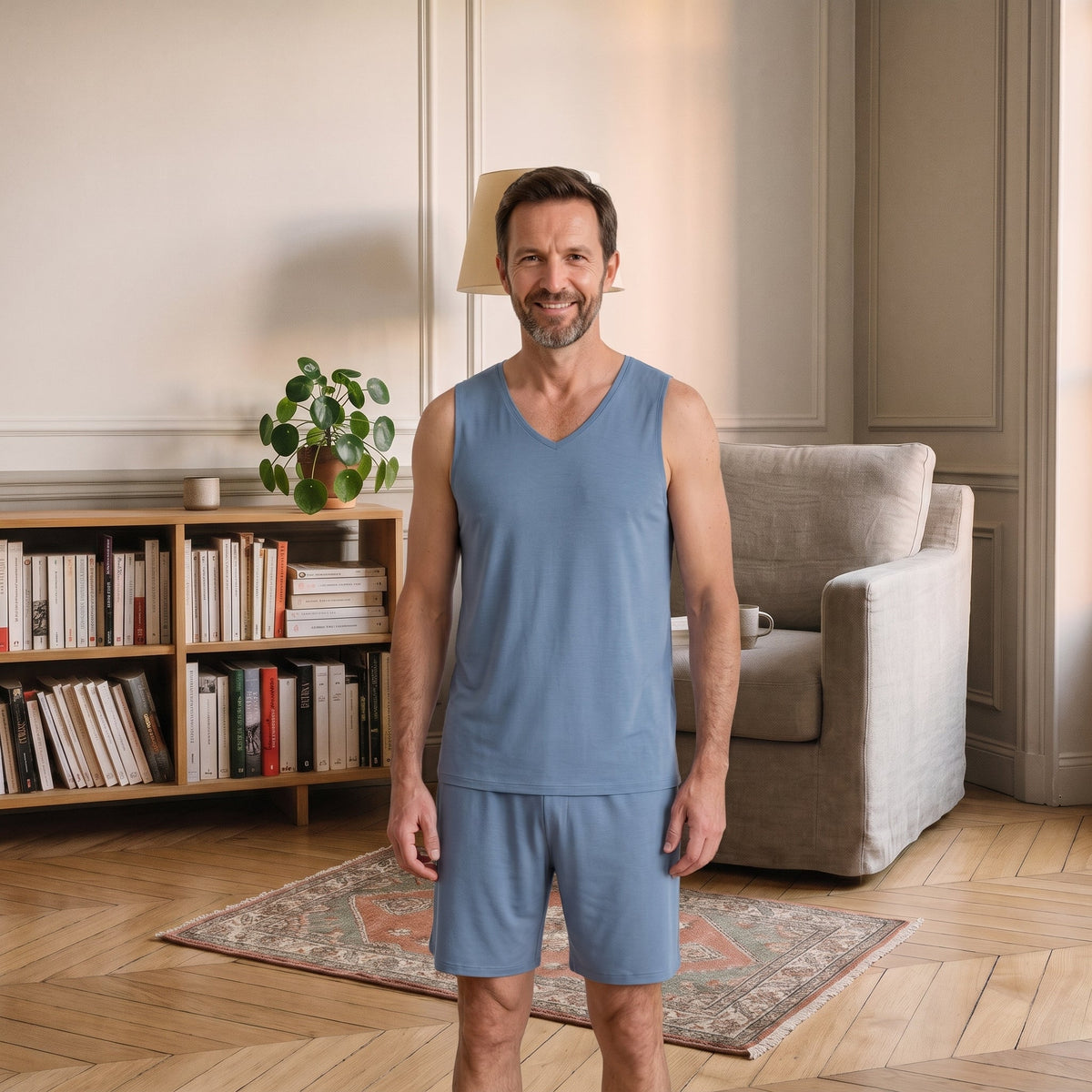 Homme du casting portant le pyjama bleu avec débardeur à col V et short.