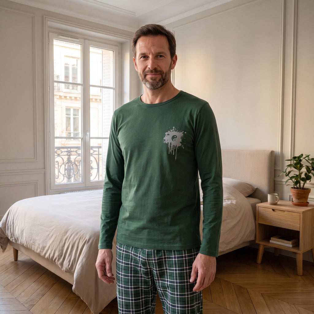 Homme de face en ensemble pyjama de coton dans une chambre, la sérigraphie visible sur la poitrine
