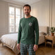 Homme de face en ensemble pyjama de coton dans une chambre, la sérigraphie visible sur la poitrine
