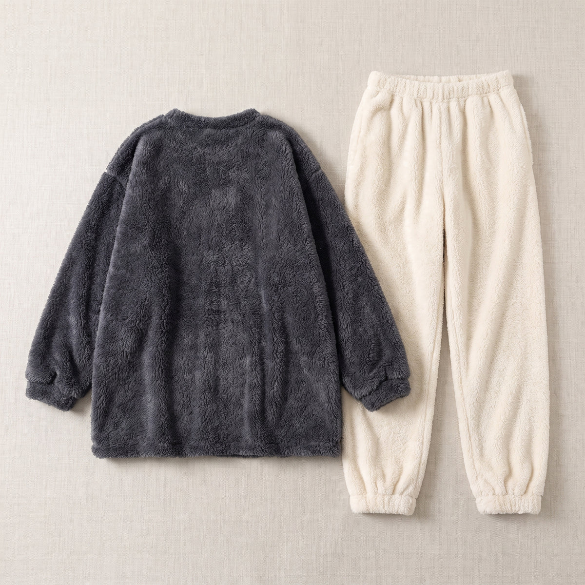 Ensemble de pyjama anthracite et écru posé à plat, haut ample et pantalon long