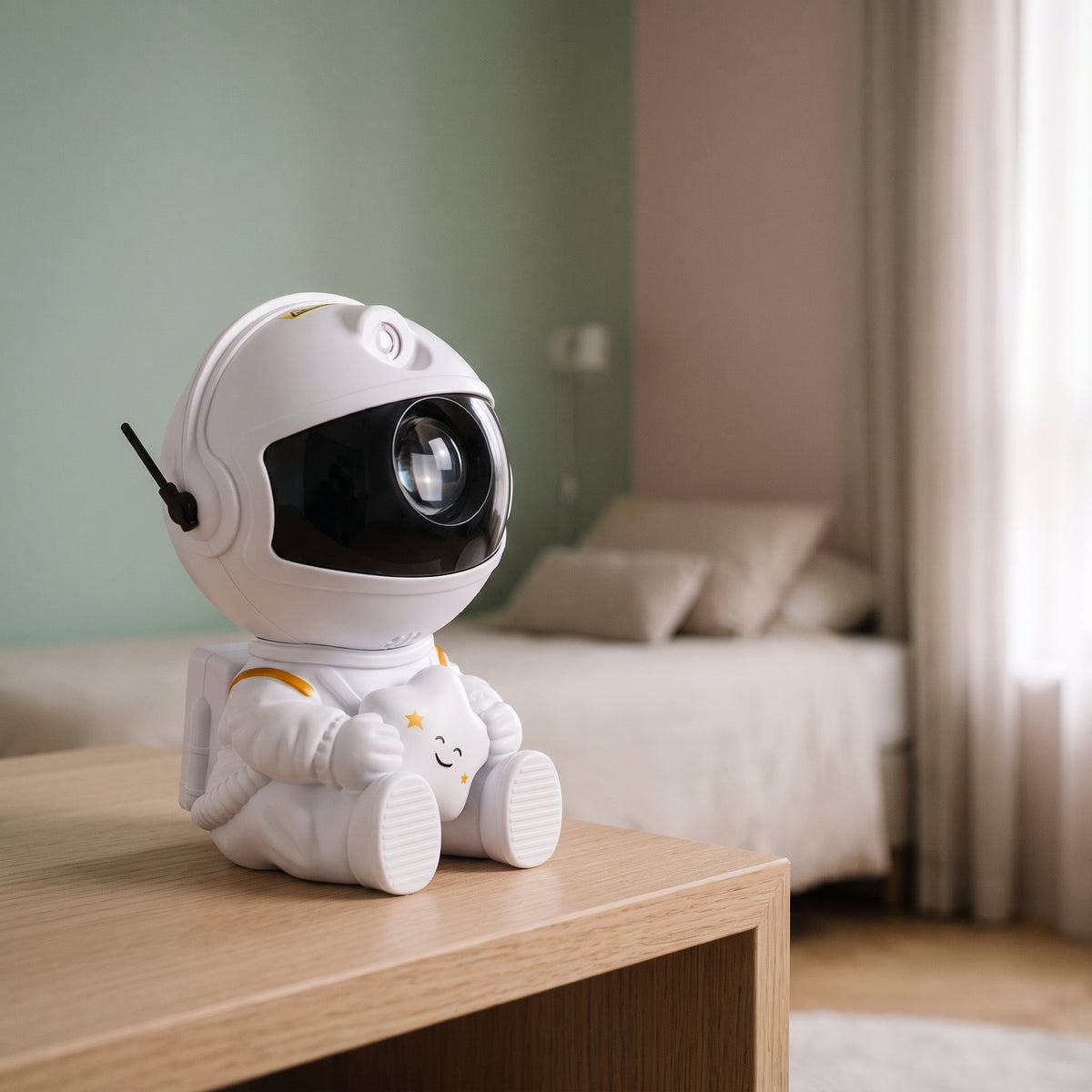 Veilleuse projecteur astronaute blanc tenant une étoile, posée sur une table de chevet
