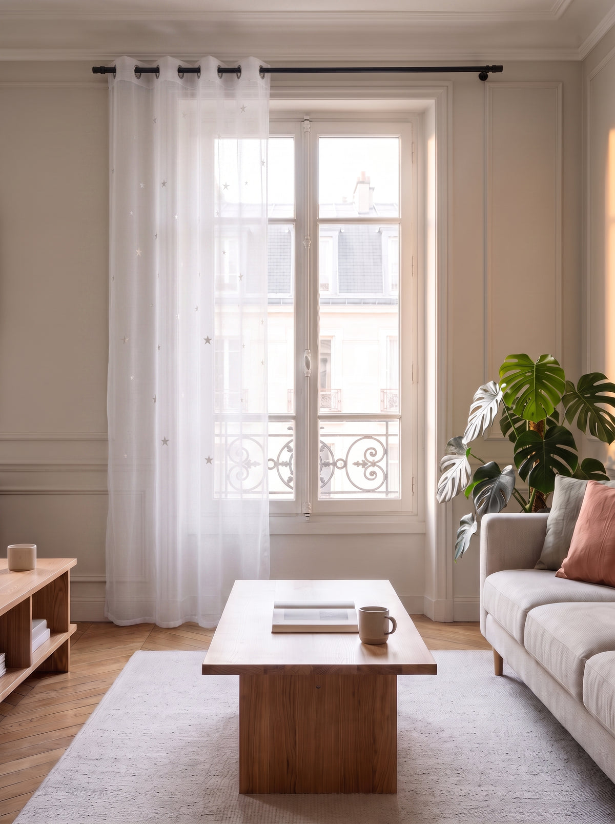 Voilage en tulle blanc a etoiles ajourees devant une fenetre de salon