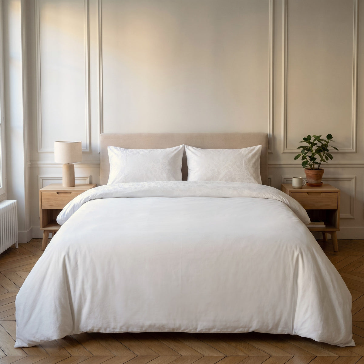 Parure de lit bi-matière blanche, housse unie et bande de velours frappé, sur un lit fait