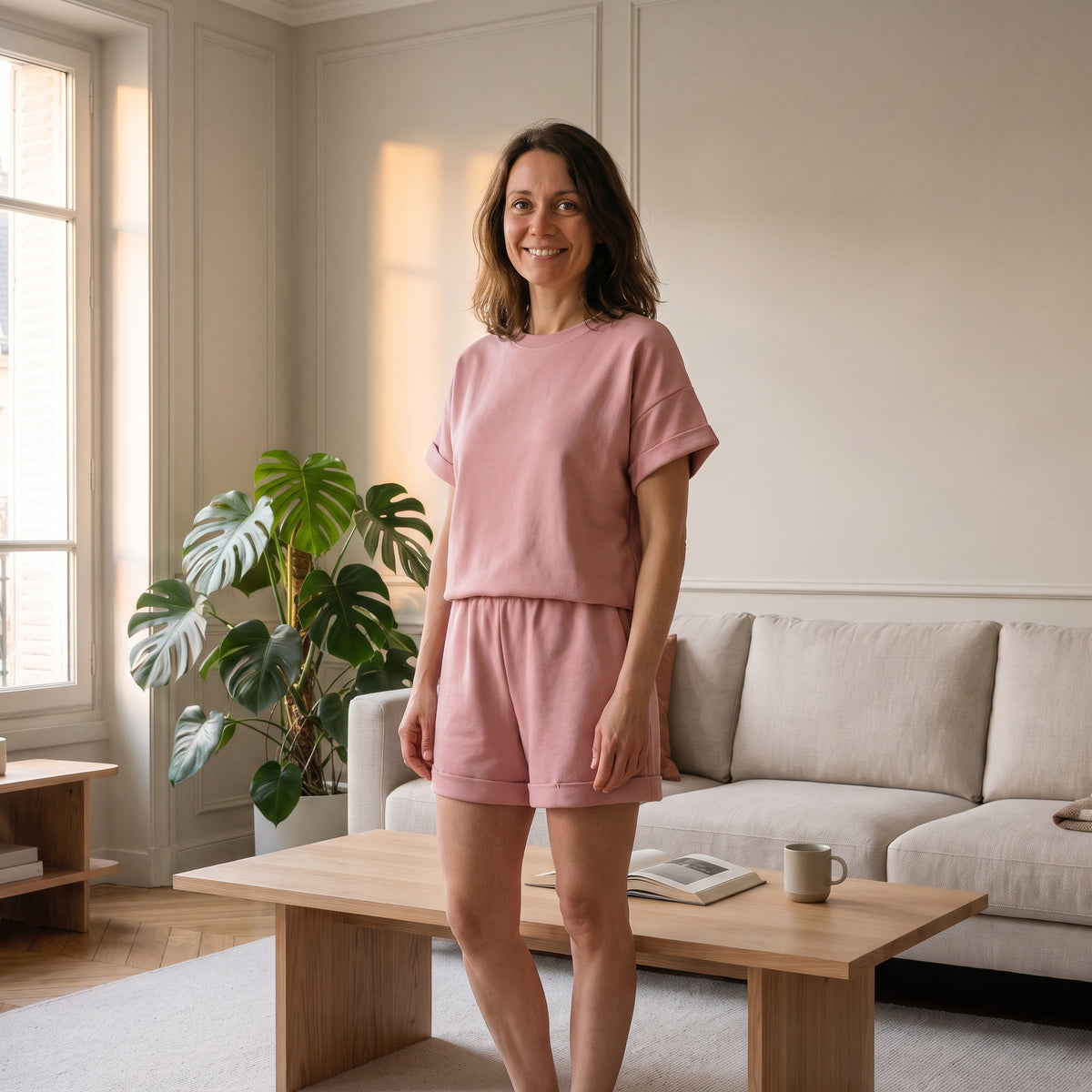 Femme en ensemble short et t-shirt en coton rose dans un salon