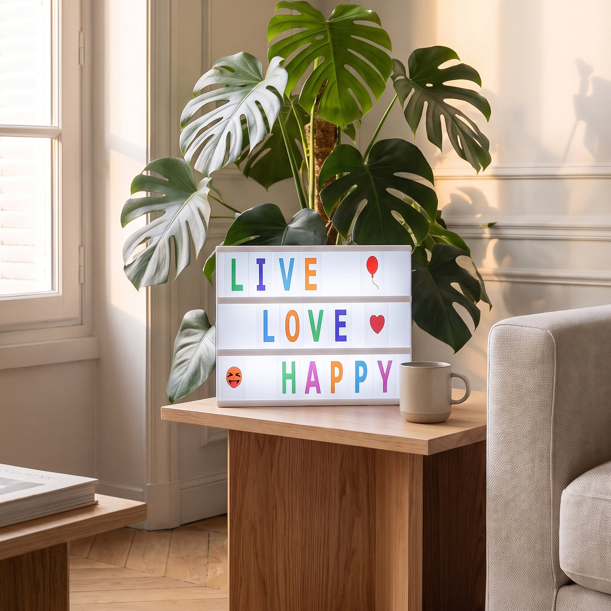 Boite lumineuse blanche avec lettres colorees, sur une table d appoint