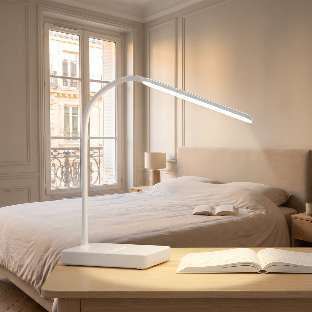 Lampe de bureau LED blanche allumée sur une table, dans une chambre claire
