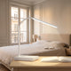 Lampe de bureau LED blanche allumée sur une table, dans une chambre claire