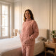 Pyjama polaire rose porté dans une chambre, mains dans la poche
