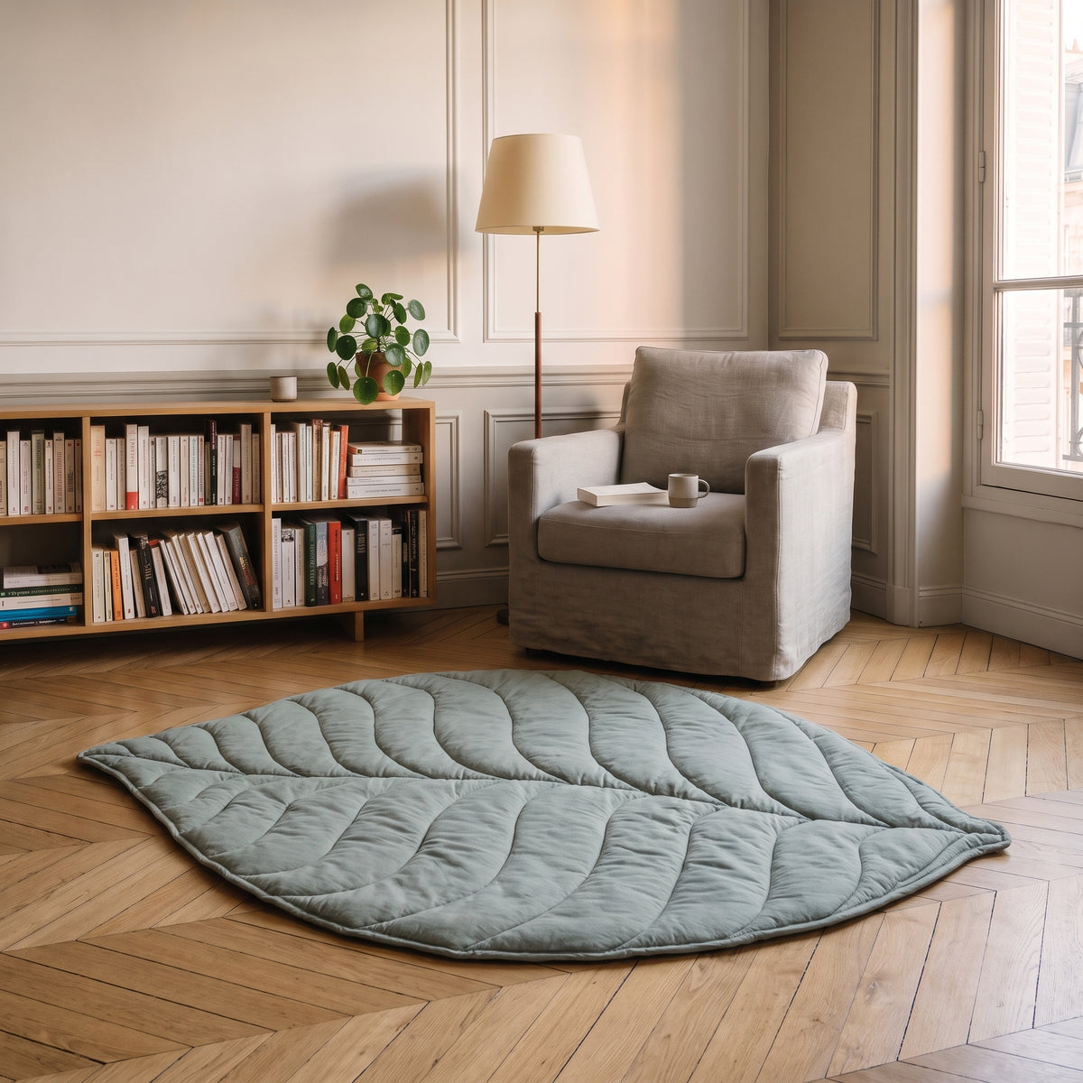 Tapis en forme de feuille vert d'eau posé devant un fauteuil de lecture
