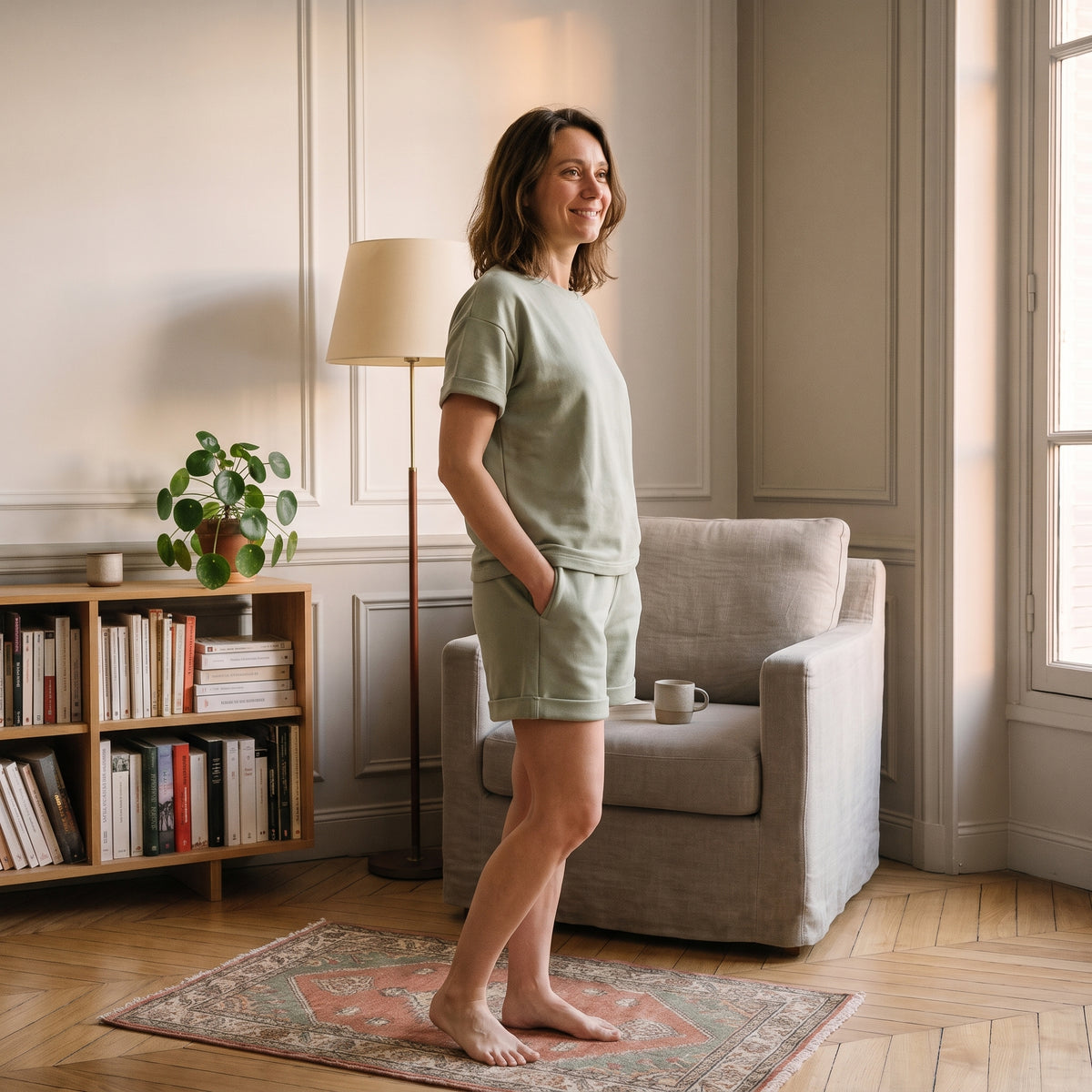 Femme en ensemble short et t-shirt en coton vert amande dans un coin lecture