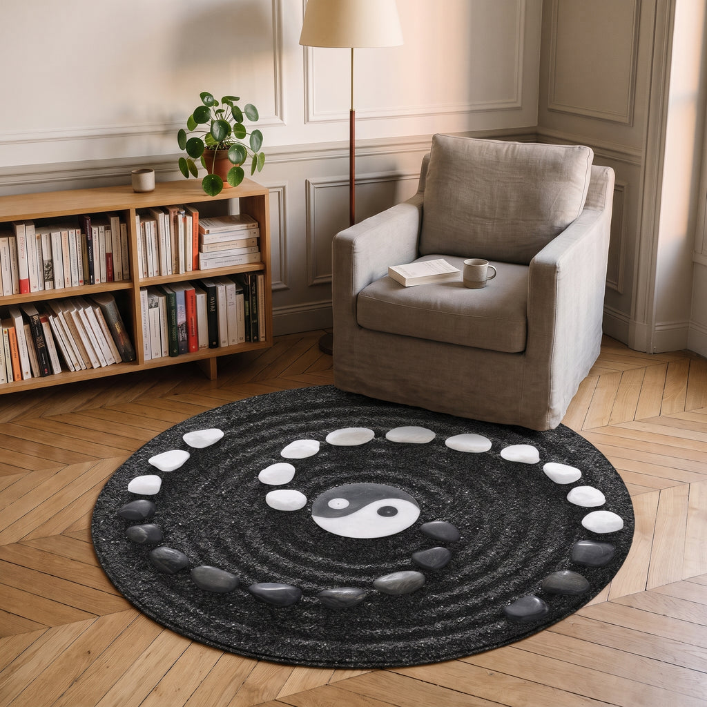 Tapis rond zen noir et blanc, motif yin yang et galets, posé sur le parquet d'un coin lecture