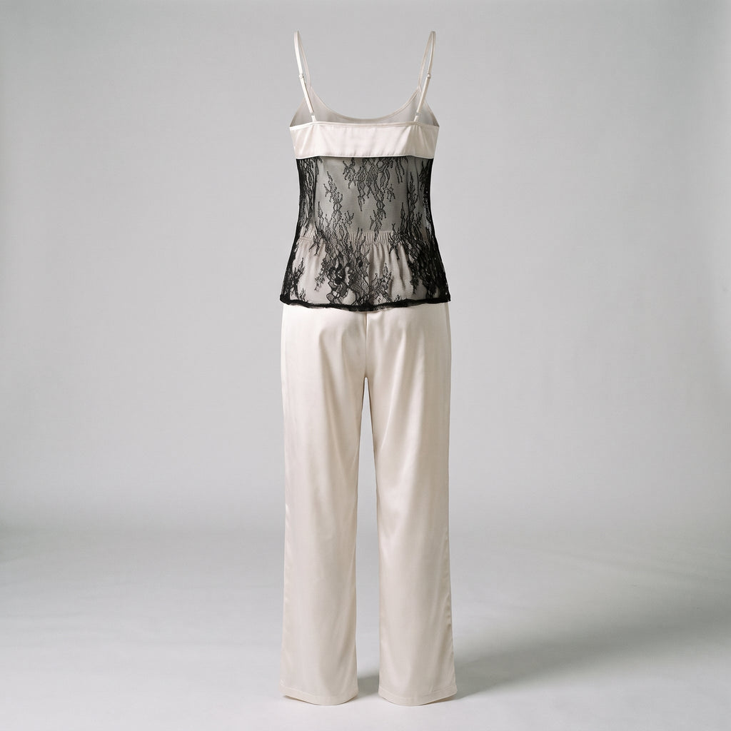 Ensemble de nuit en satin blanc casse sur mannequin invisible vu de dos, panneau de dentelle noire et pantalon long